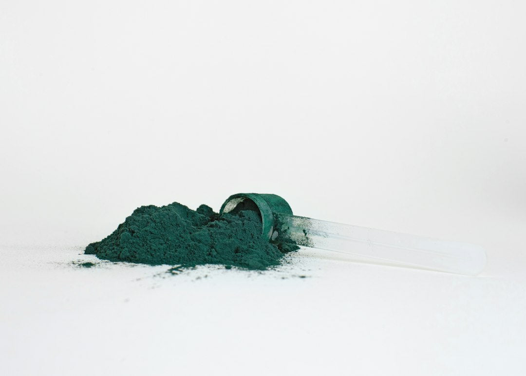 Gebruiker roert door het groene spirulinamengsel